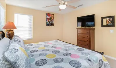 a bedroom with a bed and a flat screen tv at Emerald Island Getaway – Sleeps 13! in Kissimmee