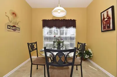 a dining room with a table and chairs and a window at Family Villa Near Disney with Private Pool in Kissimmee