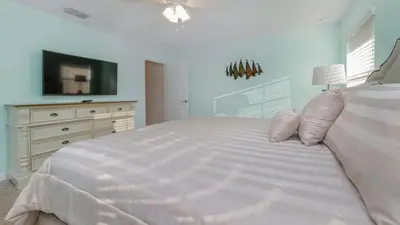 a white bedroom with a large bed and a dresser at Gatsby Escape: Private Pool Near Disney & Resorts in Kissimmee