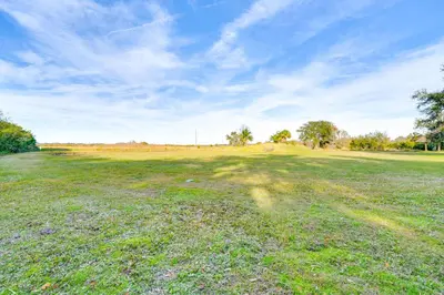 a large open field with a blue sky and trees at Nature-Packed Family Escape Near Lake Tohopekaliga in Kissimmee