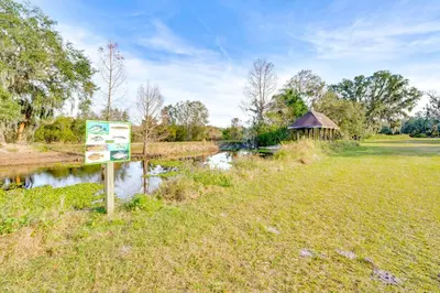 a sign next to a river with a bridge at Nature-Packed Family Escape Near Lake Tohopekaliga in Kissimmee