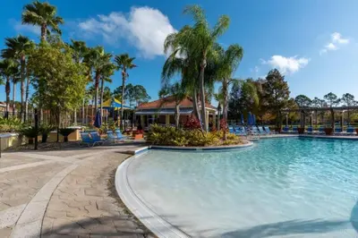 a swimming pool at a resort with palm trees at Hogwarts Escape: Magical Retreat Near Disney in Kissimmee