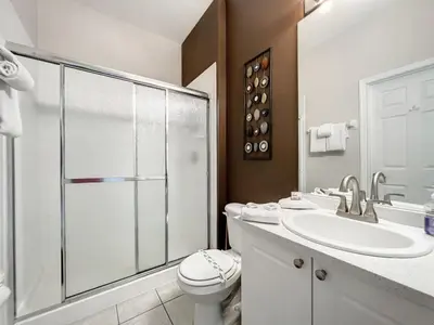 a bathroom with a toilet and a sink and a shower at Krista's Tropical Escape: Resort Stay Near Disney in Kissimmee
