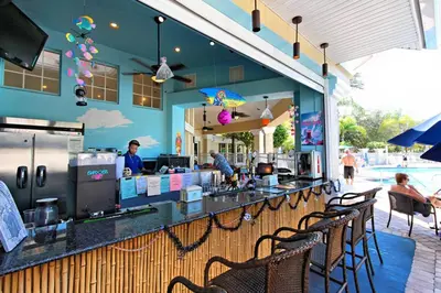 a restaurant with a bar with chairs and a pool at Krista's Tropical Escape: Resort Stay Near Disney in Kissimmee