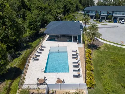 an overhead view of a swimming pool with chairs and a building at Prime Location 4BD Townhome with pool and Grill in Kissimmee