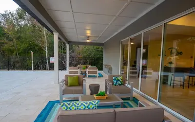 an outdoor patio with couches and tables and chairs at Prime Location 4BD Townhome with pool and Grill in Kissimmee