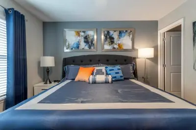 a bedroom with a large blue bed with pillows at Prime Location 4BD Townhome with pool and Grill in Kissimmee