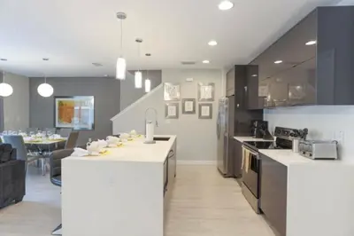 a kitchen with white counter tops and a dining room at Prime Location 4BD Townhome with pool and Grill in Kissimmee