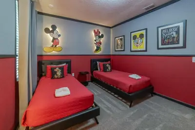 a bedroom with two beds and red walls at Mario Bros Game room 8BD Pool Movie Room 2622 in Kissimmee