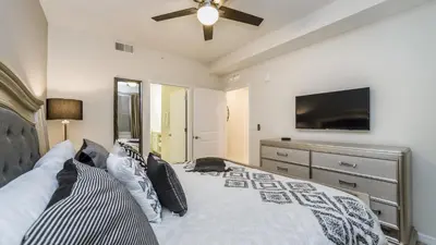 a bedroom with a bed with a ceiling fan and a television at CTD4741-102 in Kissimmee