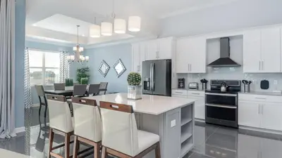 a kitchen with white cabinets and a table and chairs at CTD4751-401 in Kissimmee