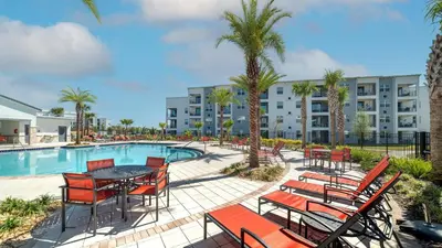 a patio with a table and chairs next to a pool at CTD4751-401 in Kissimmee