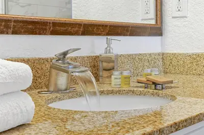a bathroom sink with a water faucet and towels at 12538 INTERNATIONAL DRIVE #C303 ORLANDO 2BED in Orlando