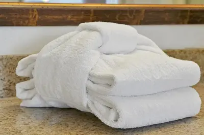 a pile of white towels sitting on a bathroom counter at 12538 INTERNATIONAL DRIVE #C303 ORLANDO 2BED in Orlando