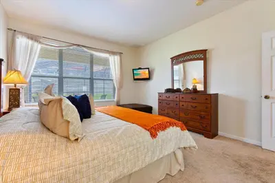 a bedroom with a bed and a dresser and a mirror at MNL2678 in Orlando