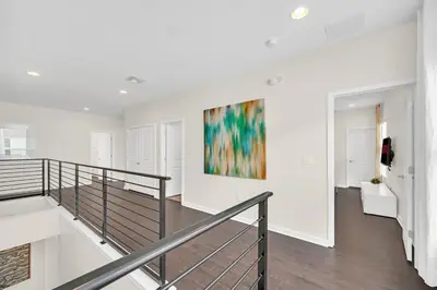 a staircase in a white room with a painting on the wall at LAKE VILLA 6bd, all un-suite, pool, spa, grill in Kissimmee