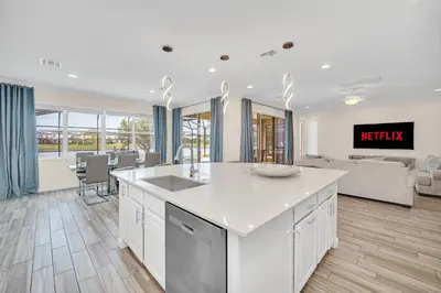 a kitchen with a sink and a living room at LAKE VILLA 6bd, all un-suite, pool, spa, grill in Kissimmee
