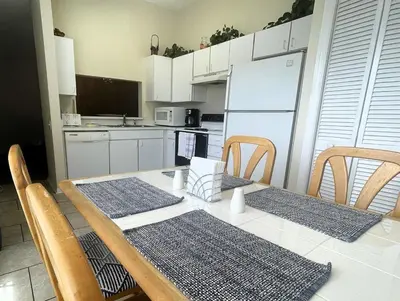 a kitchen with a table with chairs and a white refrigerator at 2950 COTTAGE GROVE COURT ORLANDO 3BED in Orlando