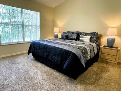 a bedroom with a large bed and a window at 2950 COTTAGE GROVE COURT ORLANDO 3BED in Orlando