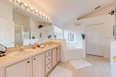 a large bathroom with two sinks and a tub and a bath tub at Pool home close to Golfing and Theme parks in Orlando