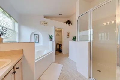 a bathroom with a shower and a sink and a tub at Pool home close to Golfing and Theme parks in Orlando