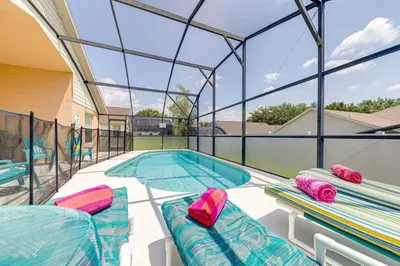 a swimming pool with two chaise lounges next to a swimming pool at Pool home close to Golfing and Theme parks in Orlando