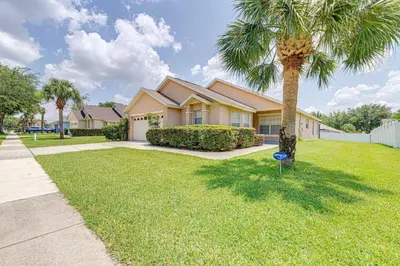 a palm tree in front of a house at Pool home close to Golfing and Theme parks in Orlando