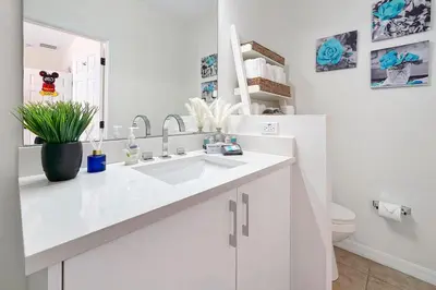 a white bathroom with a sink and a toilet at Magical serenity 3 bedroom pool home in Orlando