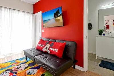 a living room with a couch and a red wall at Magical serenity 3 bedroom pool home in Orlando