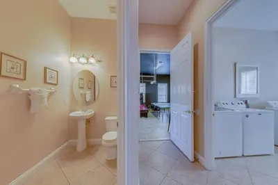 a bathroom with a toilet and a sink and a mirror at Luxury Pool Home - Disney View in Orlando