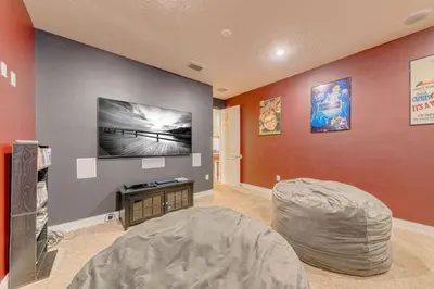 a living room with a bean bag chair and a tv at Luxury Pool Home - Disney View in Orlando