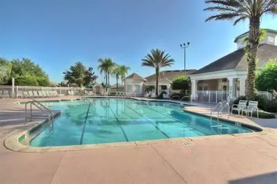 a large swimming pool in a resort with palm trees at Mickey's Play House: Family Fun & Comfort in Kissimmee