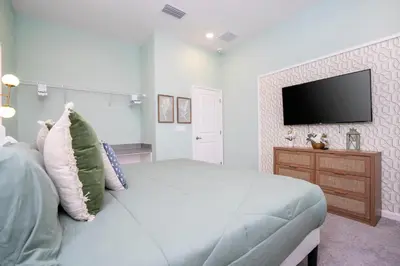 a bedroom with a bed and a tv on a wall at 5761 HS - Spacious Luxury Villa in Paradiso Grande in Orlando