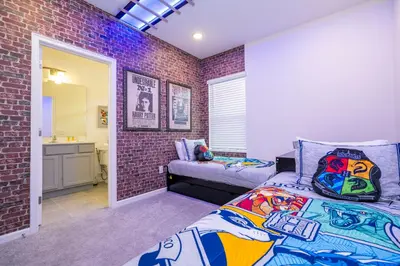 a bedroom with a bed and a brick wall at 5761 HS - Spacious Luxury Villa in Paradiso Grande in Orlando
