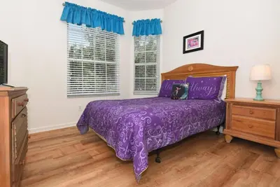 a purple bed with a purple bedspread in a bedroom at Orangebaum Condo: 8 Min to Disney + Resort Perks in Kissimmee