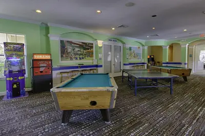 a gaming room with two pool tables and arcade machines at Orangebaum Condo: 8 Min to Disney + Resort Perks in Kissimmee