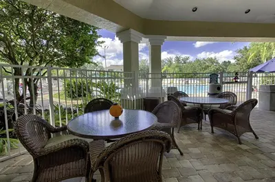 a patio with tables and chairs and a pool at Orangebaum Condo: 8 Min to Disney + Resort Perks in Kissimmee