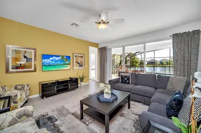 a living room with a couch and a table at DREAM VILLA 6bd, all en-suite, pool, spa, grill, theatre in Kissimmee