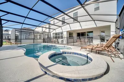 an indoor swimming pool with a glass ceiling at DREAM VILLA 6bd, all en-suite, pool, spa, grill, theatre in Kissimmee