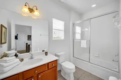 a bathroom with a shower and a toilet and a sink at DREAM VILLA 6bd, all en-suite, pool, spa, grill, theatre in Kissimmee