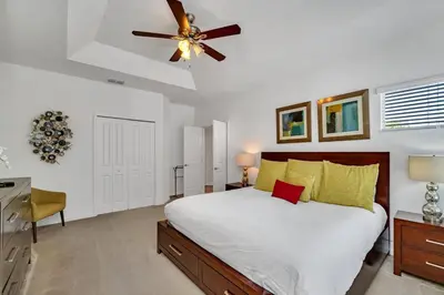 a bedroom with a bed and a ceiling fan at DREAM VILLA 6bd, all en-suite, pool, spa, grill, theatre in Kissimmee