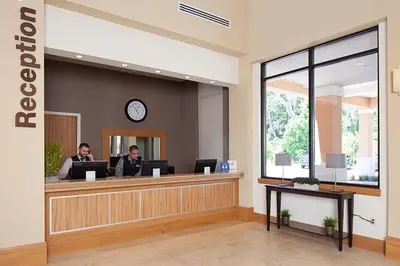 two people sitting at a reception desk in a lobby at Regal Oaks Retreat: Pool, Hot Tub & Near Disney in Kissimmee