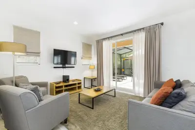 a living room with two couches and a tv at Regal Oaks Retreat: Pool, Hot Tub & Near Disney in Kissimmee