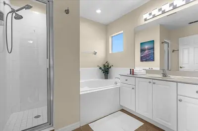 a bathroom with a tub and a sink and a shower at Spacious 7-Bedroom Home at Bella Vida Resort with Conservation View in Kissimmee