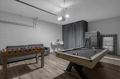 a living room with a pool table and a couch at Spacious 7-Bedroom Home at Bella Vida Resort with Conservation View in Kissimmee