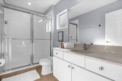 a bathroom with a toilet and a sink and a shower at Spacious 7-Bedroom Home at Bella Vida Resort with Conservation View in Kissimmee