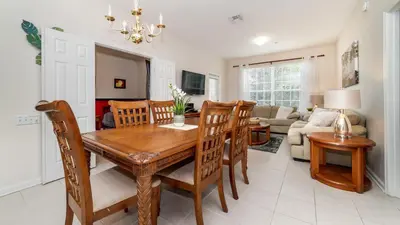 a dining room and living room with a wooden table and chairs at ALM2774-204 in Orlando