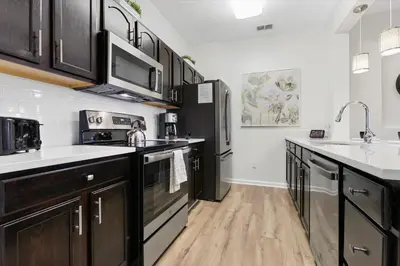 a kitchen with black and white appliances and wooden floors at ALM2774-403 in Orlando