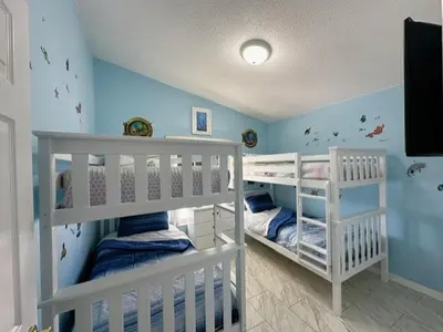 two bunk beds in a room with blue walls at Relax Away Villa: Private Pool Home Near Disney in Orlando