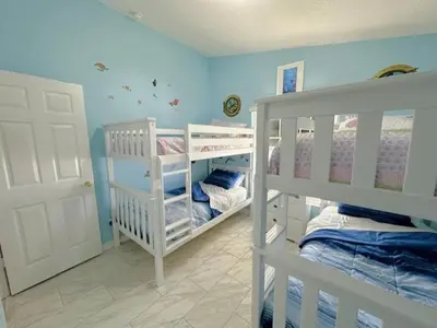 two white bunk beds in a room with blue walls at Relax Away Villa: Private Pool Home Near Disney in Orlando